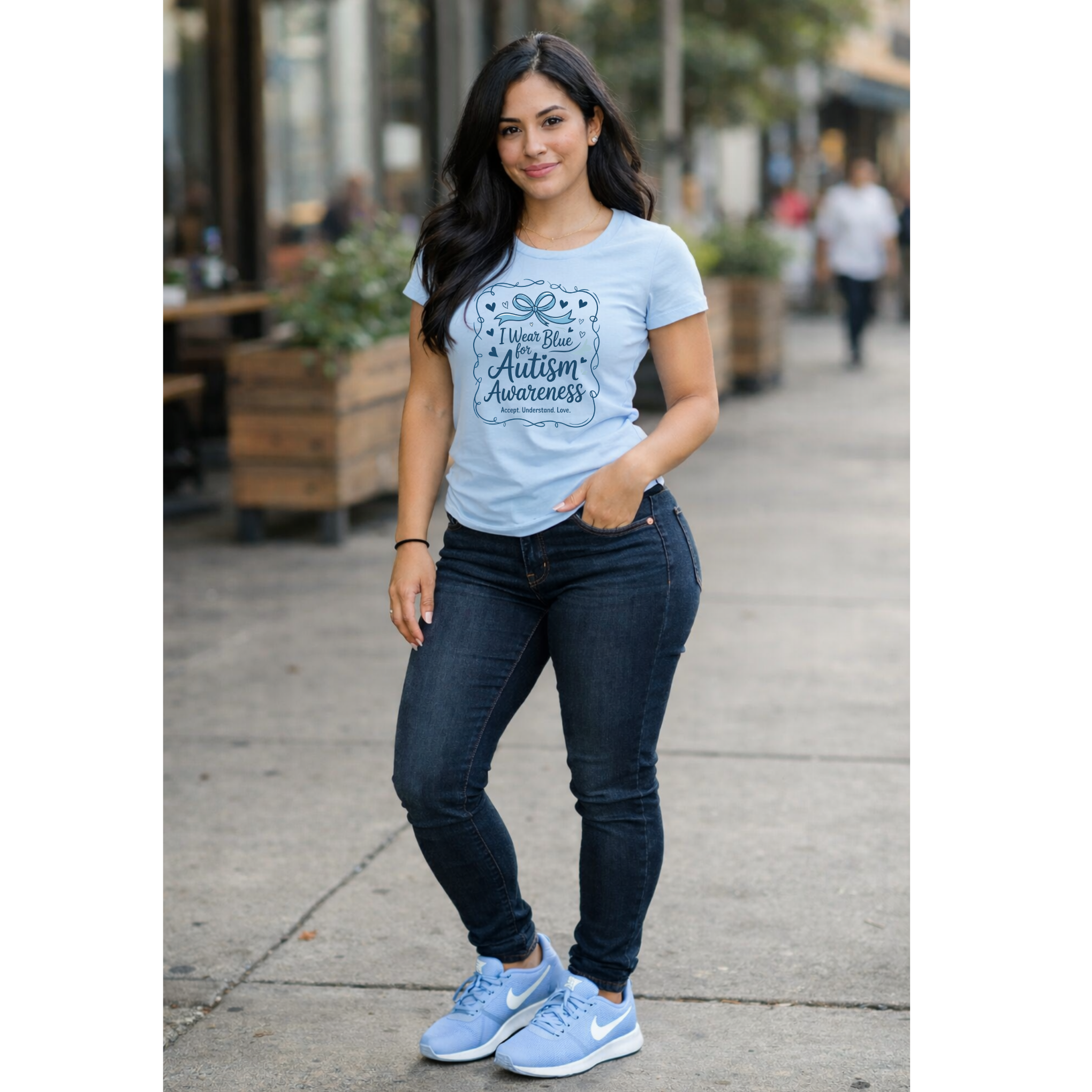 Model wearing light blue autism awareness shirt with bow design front view